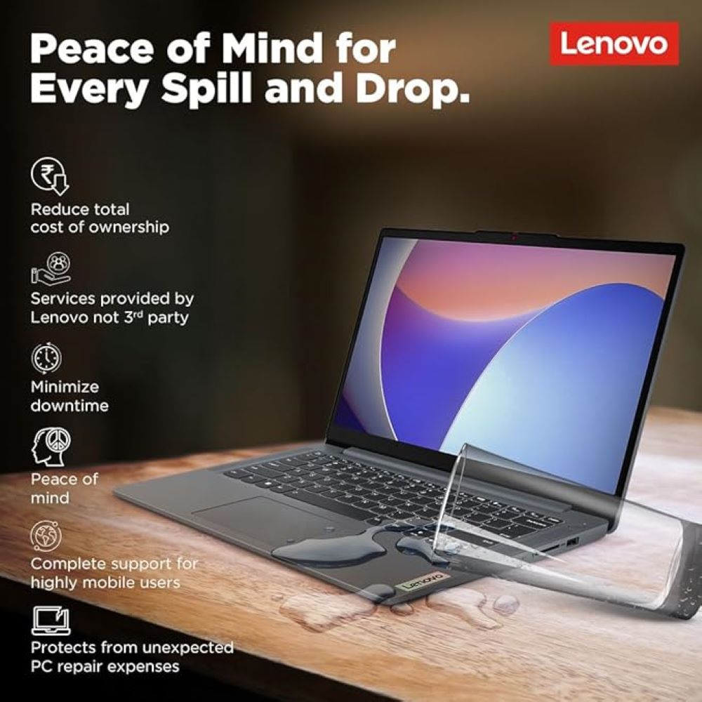 Lenovo laptop on wooden surface with water spilled over it; screen shows abstract design and promotional text about Lenovo’s protection services for spills and drops.